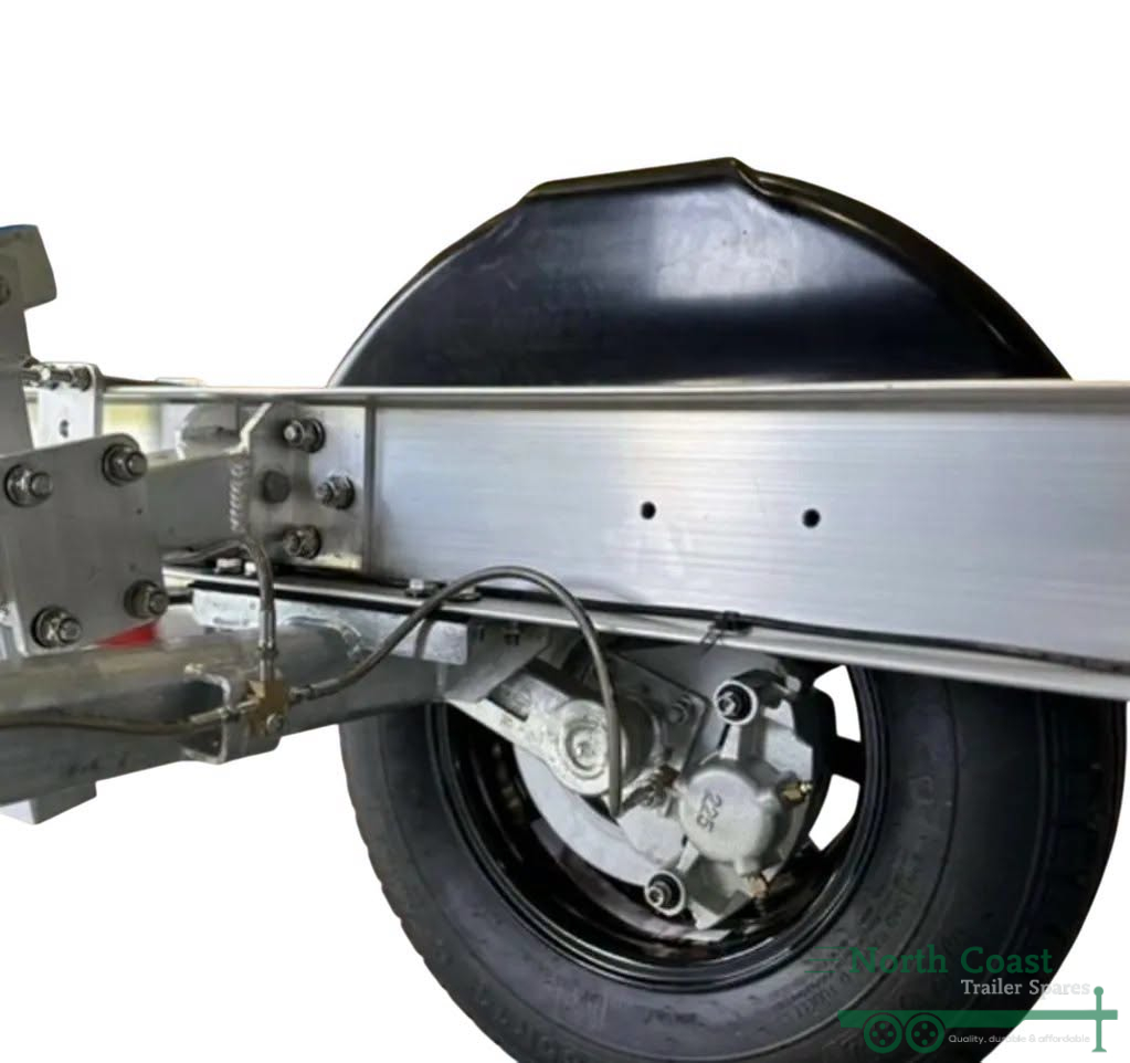 "Close-up of a boat trailer hydraulic disc brake caliper assembly, stainless steel brake lines, independent torsion axle arm, and black alloy wheel."