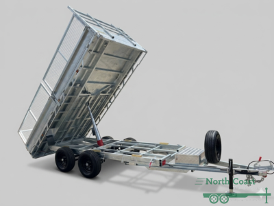 Studio shot of an empty 14x7 extra heavy duty flat deck hydraulic tipping trailer showing hot-dipped galvanized checker plate flooring, dual axles, 600mm mesh cage sides, and dual slide-out rear tracking steel loading ramps.